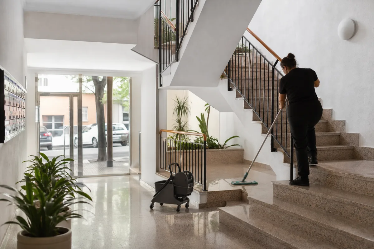 Profesional limpiando el portal y las escaleras de una comunidad de vecinos en Cáceres